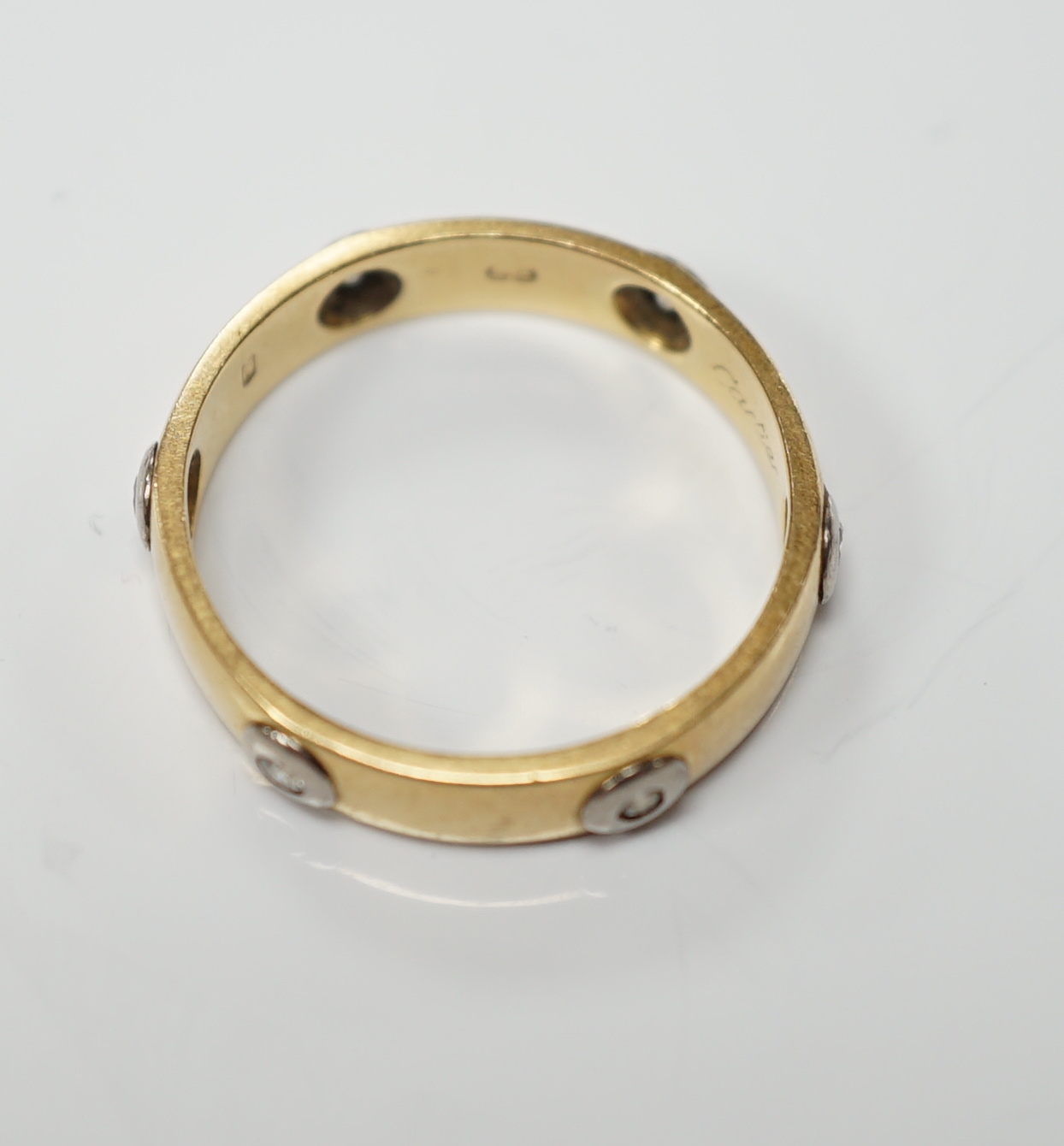 A modern Cartier 18ct gold and six stone diamond set band, signed and numbered 441404, size L, gross weight 3.3 grams, no box or certificate.
